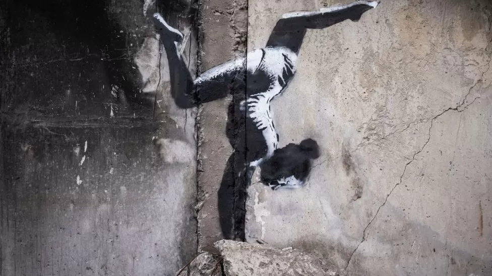 Artisti i grafitit Banksy zbulon muralin e gjimnastes në Ukrainë në ndërtesën e bombarduar nga Rusia